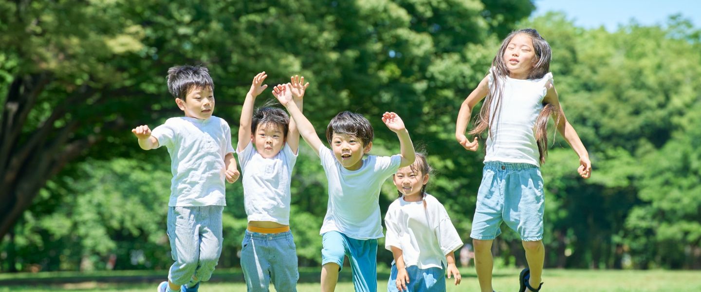 飛び跳ねて遊んでいる5人の子どもたち