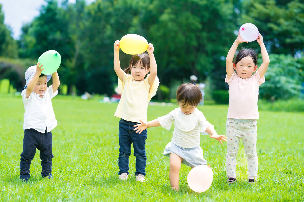 風船で遊んでいる4人の子どもたち