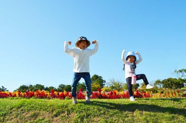 自然のなかで体操をしている2人の子ども