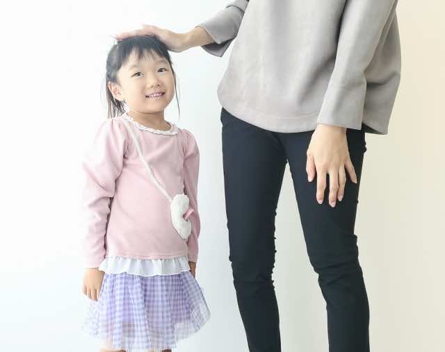 お母さんに頭を撫でられる女の子