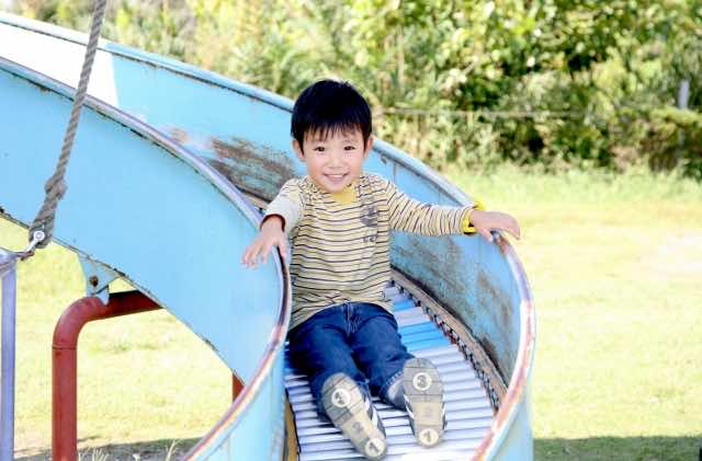 滑り台をすべる男の子