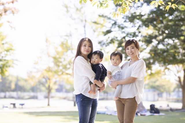 子どもを抱っこしたお母さんが2人並んでいる